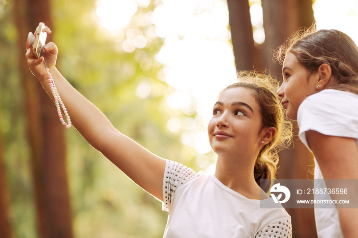 Cute girls taking selfies in the forest