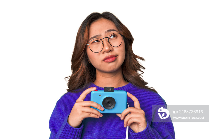 Happy Asian woman holding a retro camera.