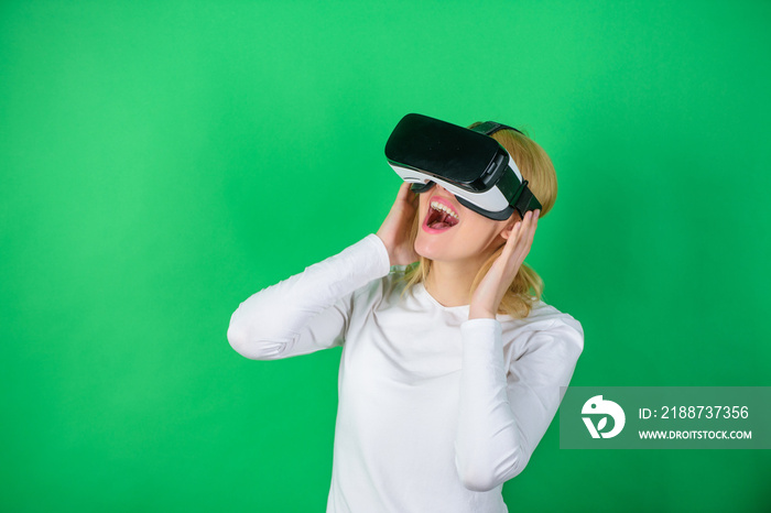 Woman using virtual reality headset. The woman with glasses of virtual reality. Woman wearing virtual reality goggles in green background. Technology, science, innovation and cyberspace concept.