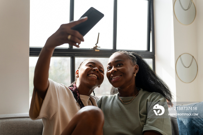 Lesbian couple taking selfie at home