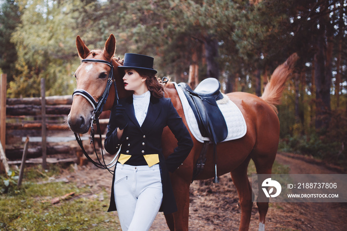 Portrait, riding, concept of advertising equestrian club caring for a horse. Jockey girl next to the horse. Corrects the bridle. Summer. Toning.