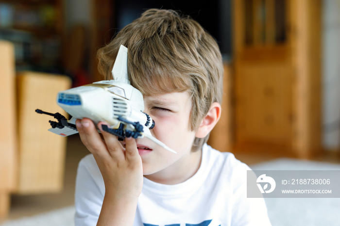 Happy little kid boy playing with space shuttle toy.