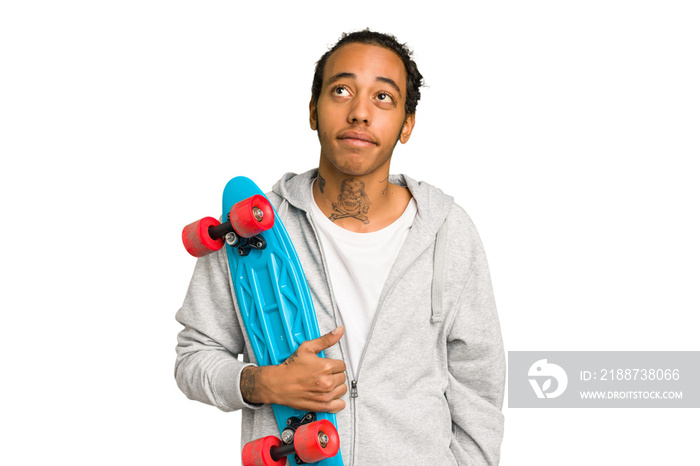 Young skater African American man isolated dreaming of achieving goals and purposes