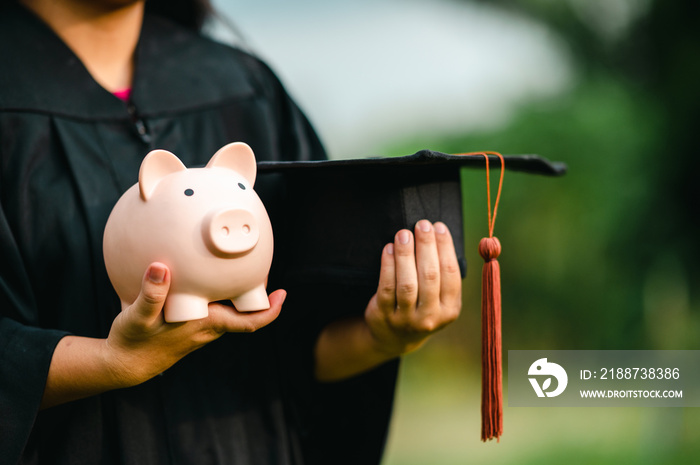 graduates holding piggy banks saving concept