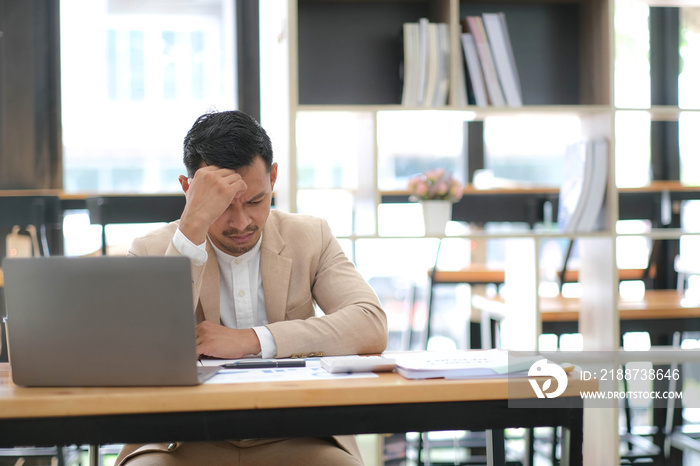 Tired frustrated young asian businessman feeling stressed holding head with hands, business problem failure concept