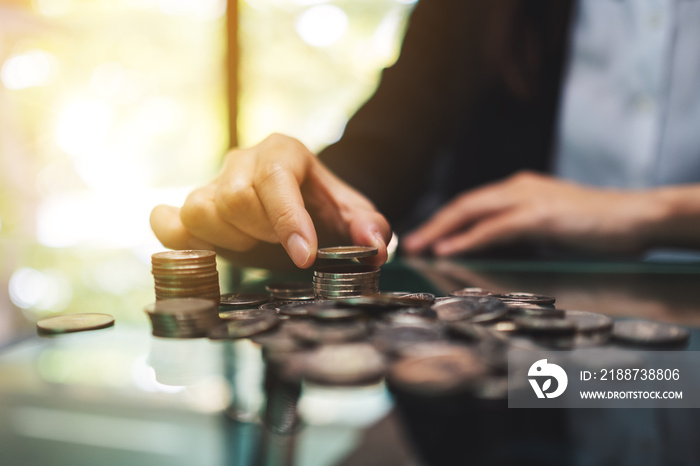 Businesswoman stacking coins on the table for saving money and financial concept