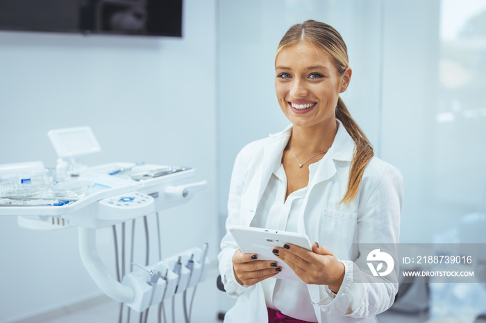 Portrait of a Caucasian woman dentist, sitting in her office next to a dentist chair, smiling. Portrait of female dentist. She standing at her office. Healthcare and medicine concept