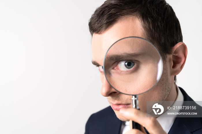 Young man holding a magnifying glass.