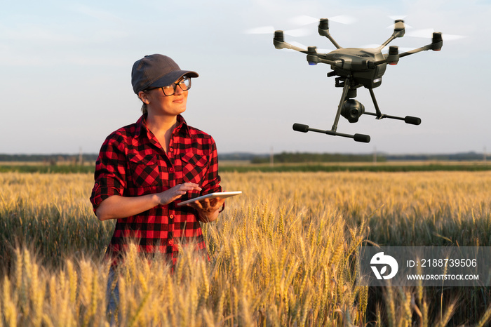 Woman farmer controls drone using a digital tablet