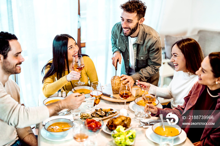 Man cutting bread - Smiling friends are having a dinner party at home - People laughing while eating soup - Friendship life style concept with young people having fun together at restaurant