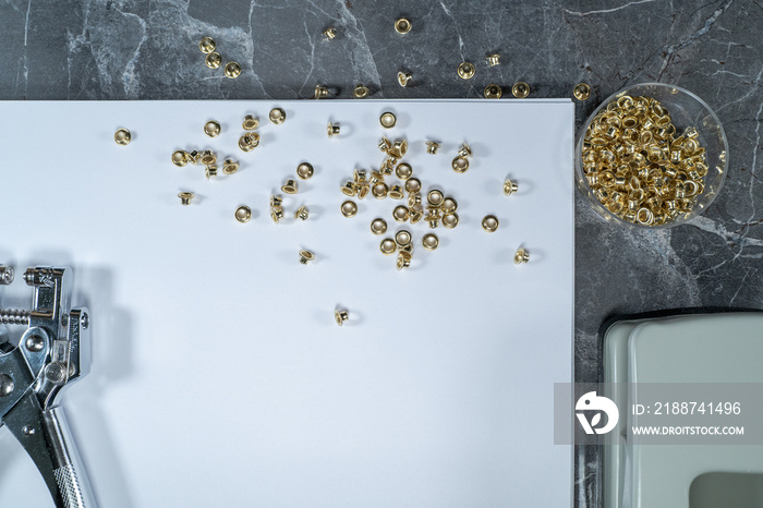 rivets scattered on a white sheet lying on a gray marble table