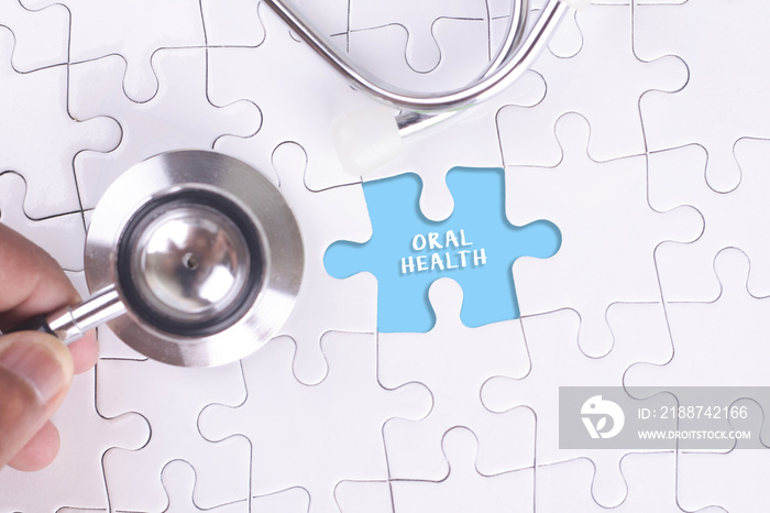 Doctor holding a Stethoscope on missing puzzle WITH ORAL HEALTH