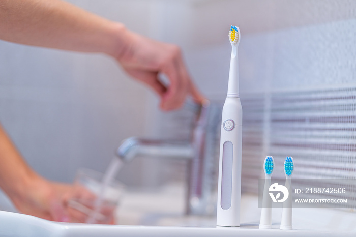 Ultrasonic electric toothbrush with interchangeable nozzles in bathroom at home. Oral hygiene, dental and gum health, healthy teeth. Dental products