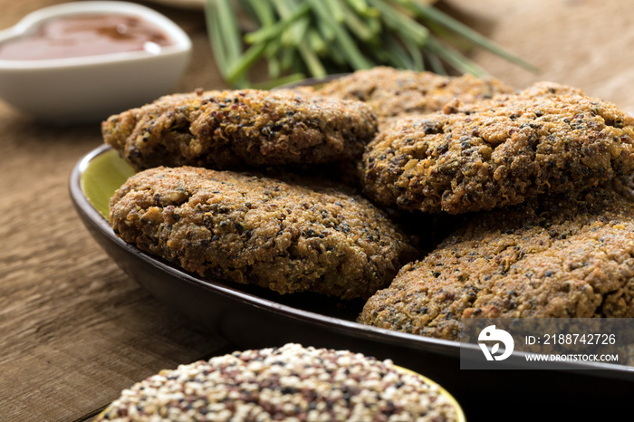 Gluten free and vegetarian quinoa hamburgers on a wooden table.