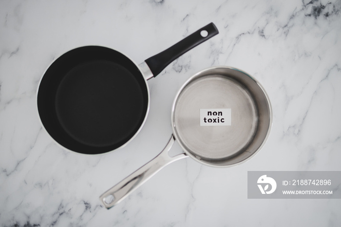 healthy cooking concept, stainless steel vs non stick saucepan side by side with Non Toxic label on the first one