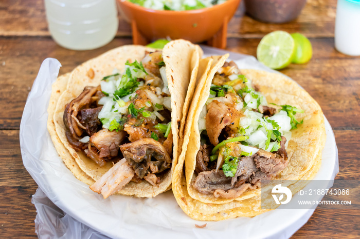 Beef tacos with onion, cilantro, sauces and a double tortilla.