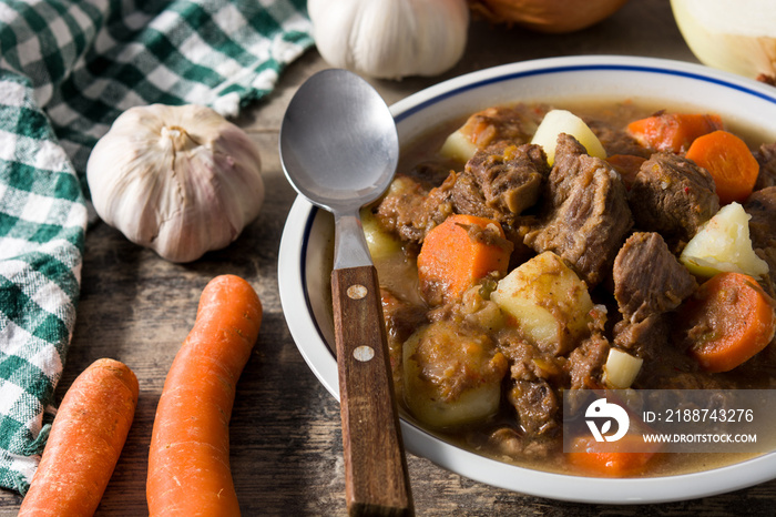 Irish beef stew with carrots and potatoes on black background