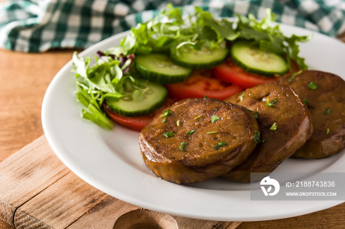 Seitan with vegetables on wooden table. Fake meat