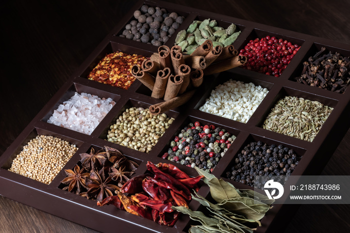 Close up of a compartment box filled with a variety of whole dry spices.