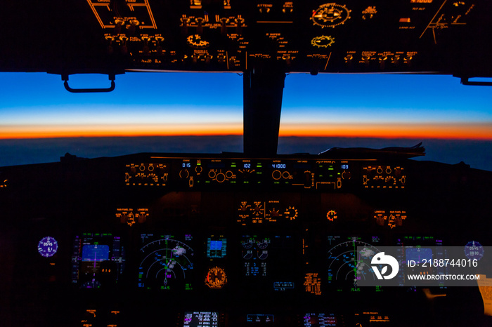 Cockpit view of sunset from Boeing 737 over Greenland at 41000 feet.