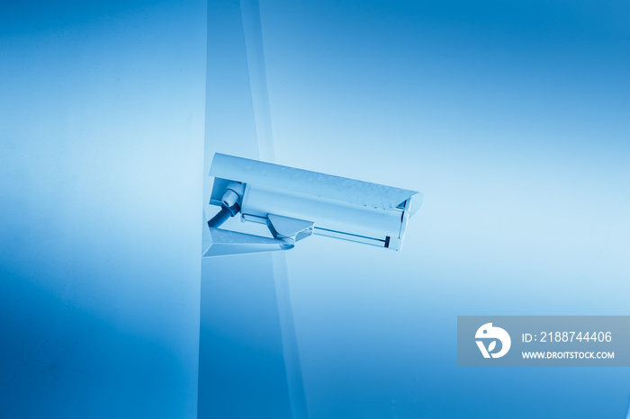 CCTV camera in the school or university campus building, white clean trust security concept blue color tone.