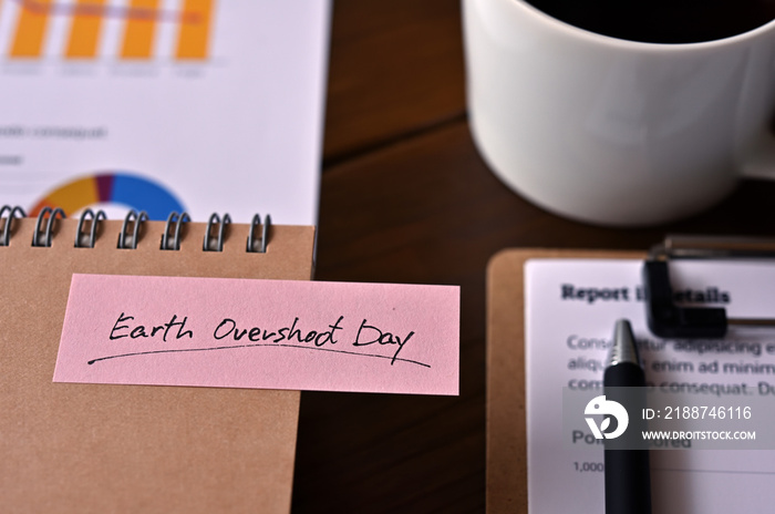 There’s dummy documents, a cup of coffee and a notebook with a sticky note stuck to it that says Earth Overshoot Day.