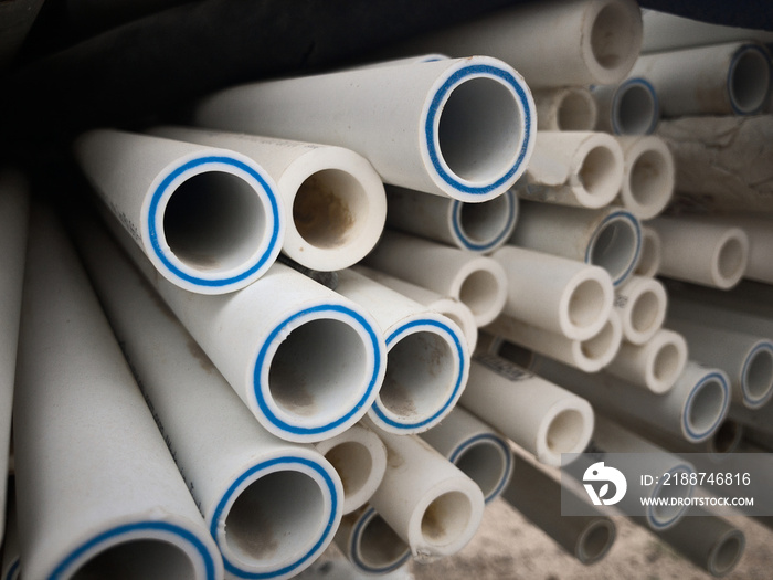 Polypropylene pipes stacked at construction site. Stack of LDPE water pipes. PVC pipes