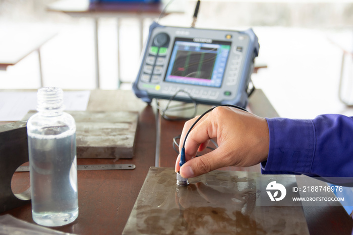 Ultrasonic testing training. Human’s hands holding a Probe Scanner for finding the imperfection or defect in the metal steel. UT scan is a family of non-destructive testing techniques.