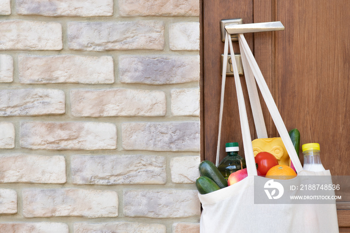 Grocery shopping in a bag hanging on door handle during a quarantine