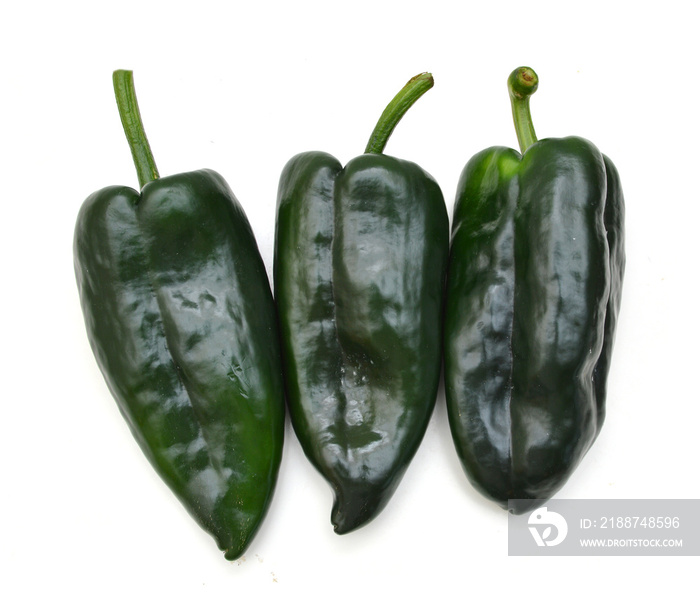 Three dark green poblano peppers isolated on white