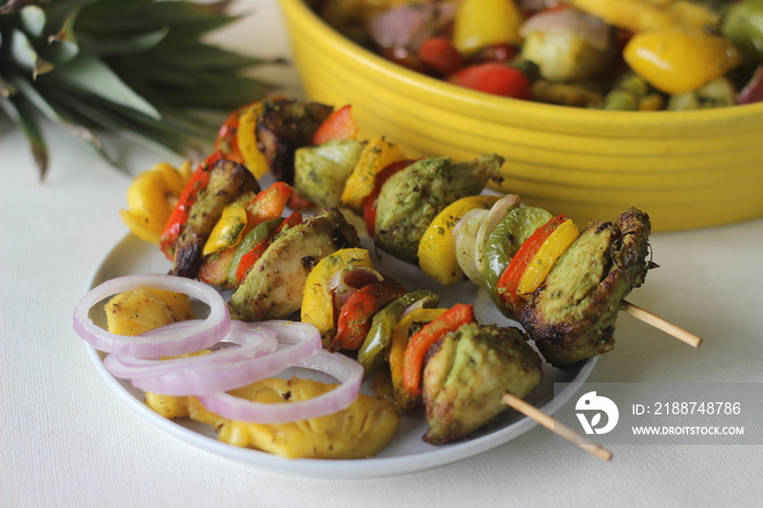 Chicken pineapple kebab. A dish of pieces of chicken and bell peppers marinated with coriander masala along with pineapple slices grilled on a skewer or spit using an air fryer