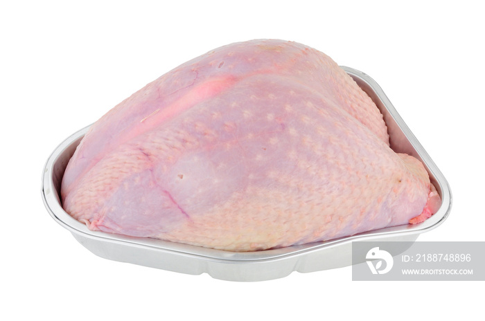 Whole raw turkey crown meat in a foil roasting tray isolated on a white background