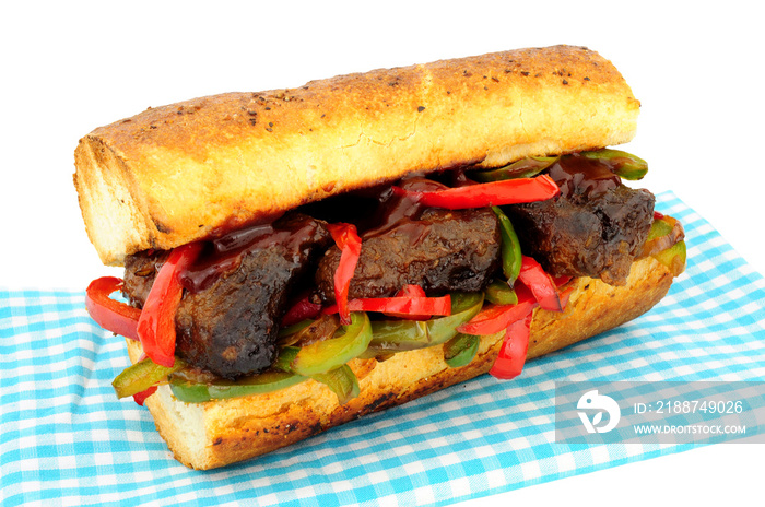 Beef burnt ends and sweet pepper sandwich in a crusty bread baton isolated on a white background