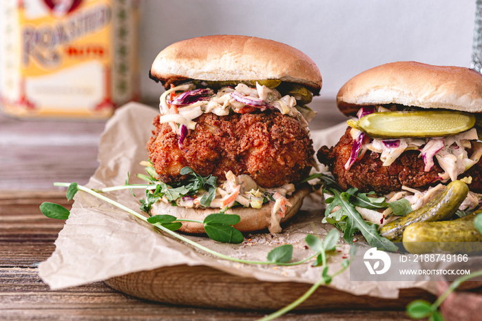 Spicy southern style fried chicken sandwich with coleslaw and pickles. Toasted burger buns. Fast food. Deep fried chicken.Rustic food photo.Crispy chicken breast.Breaded fried chicken. Unhealthy food.