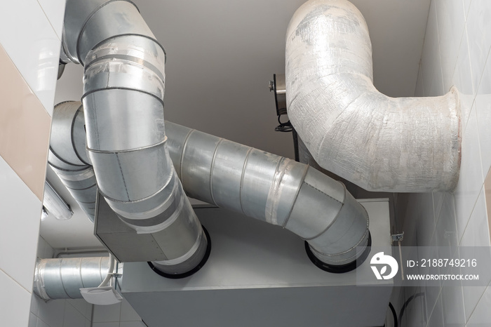 Pipes from ventilation systems or refrigeration equipment. Metal pipes under ceiling. Concept - planning ventilation networks. Installation of air conditioning systems. Indoor air distribution pipes