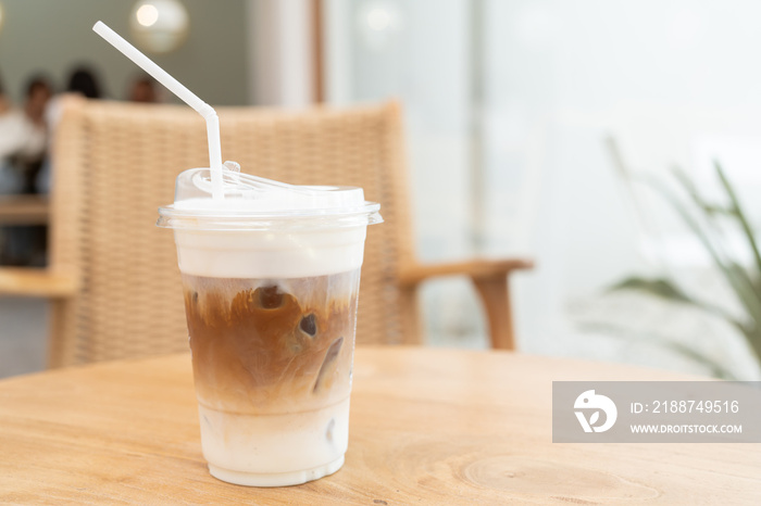 Fresh coffee, iced cappuccino, Macchiato, latte with separate milk and coffee. Coffee in a plastic cup on a wooden table. plastic iced coffee mug on wooden table