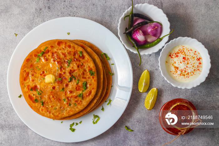 North Indian famous food Aloo Paratha with mango pickle and butter.