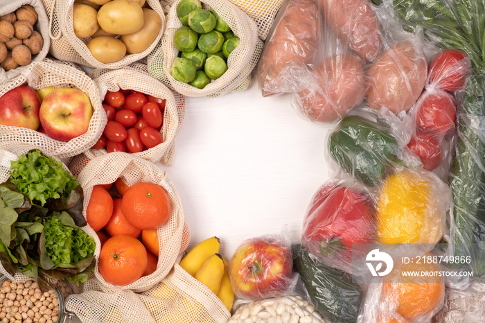 Zero waste vs plastic packaging. Fruits and vegetables in eco friendly reusable cotton bags and in plastic bags. Top view with copy space