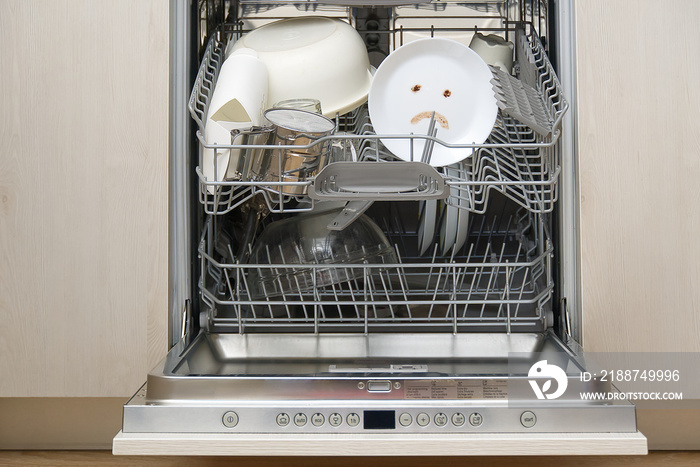 Poorly washed dishes in the dishwasher. Integrated Dishwasher with white plates front vew and sad emotion on plate. broken dishwasher machine concept