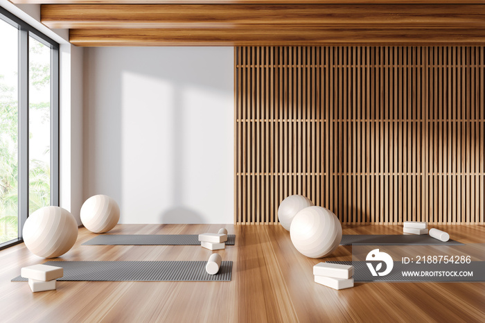 White and wooden yoga studio interior with mats and fitballs