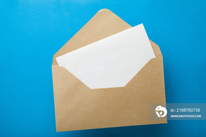 Empty letter in an envelope from recycled paper on a blue background.