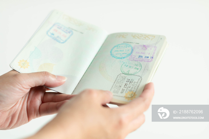 hands is holding passport with immigration stamp inside.