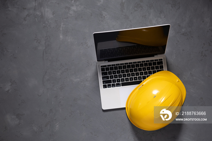 Computer laptop on cement floor. Laptop and construction tools