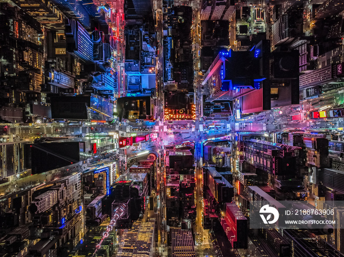 Top down shot of colourfully illuminated buildings around Times Square at night. High rise buildings in blocks in urban borough. Manhattan, New York City, USA