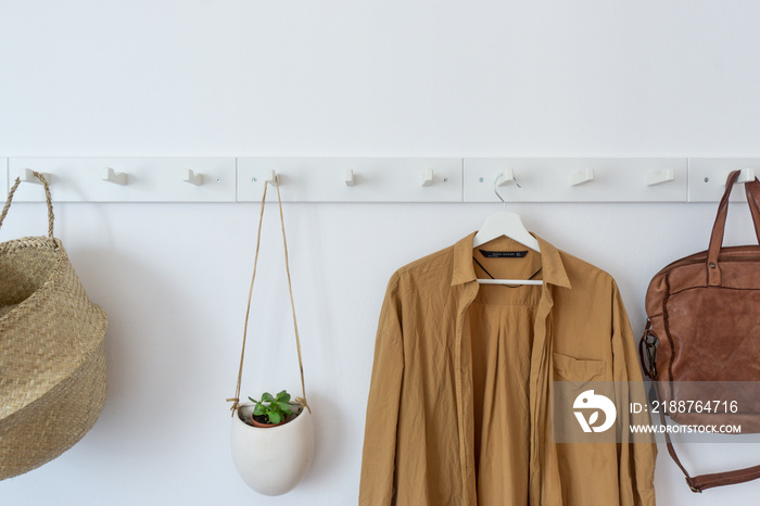 White coat-rack with clothes and accessories