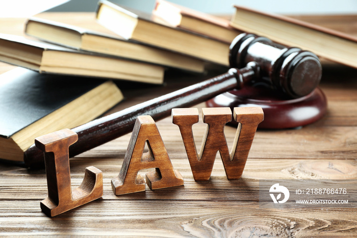 Word law with judges gavel and legal books on wooden background