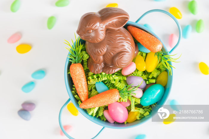 Easter basket filled with Easter grass, candy eggs, mini carrots, and a chocolate rabbit