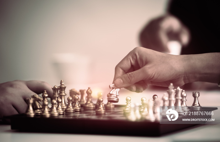 Businessman hand holding gold horse chess in competitor and win the games.