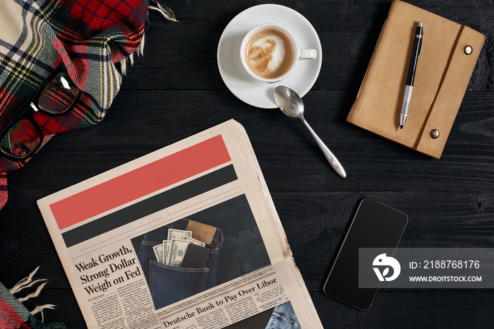 Smart phone with black display on wooden background. Newspaper and coffee on wooden table. Top view.