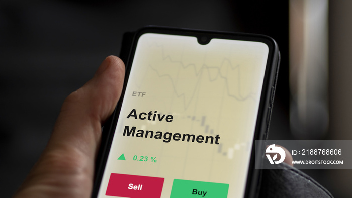 An investor’s analyzing the active management etf fund on a screen. A phone shows the prices of active-management ETF